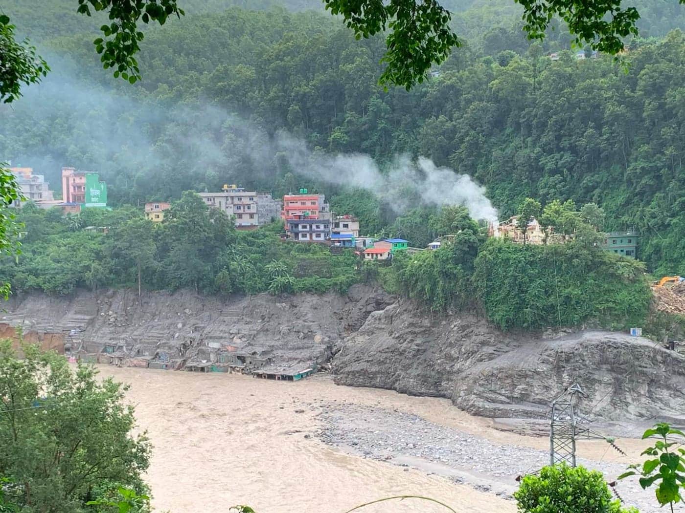 Der angeschwollene Fluss hat unterhalb der Häuser eine hohe Abbruchkante gerissen