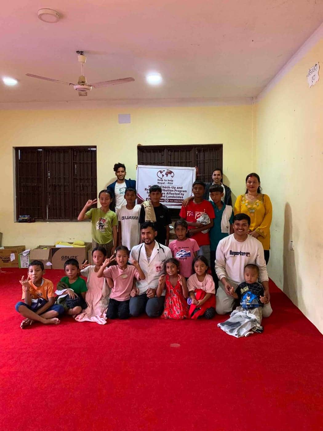 Gruppenbild mit Kindern und Helfern vor dem Banner des Hilfsprogramms