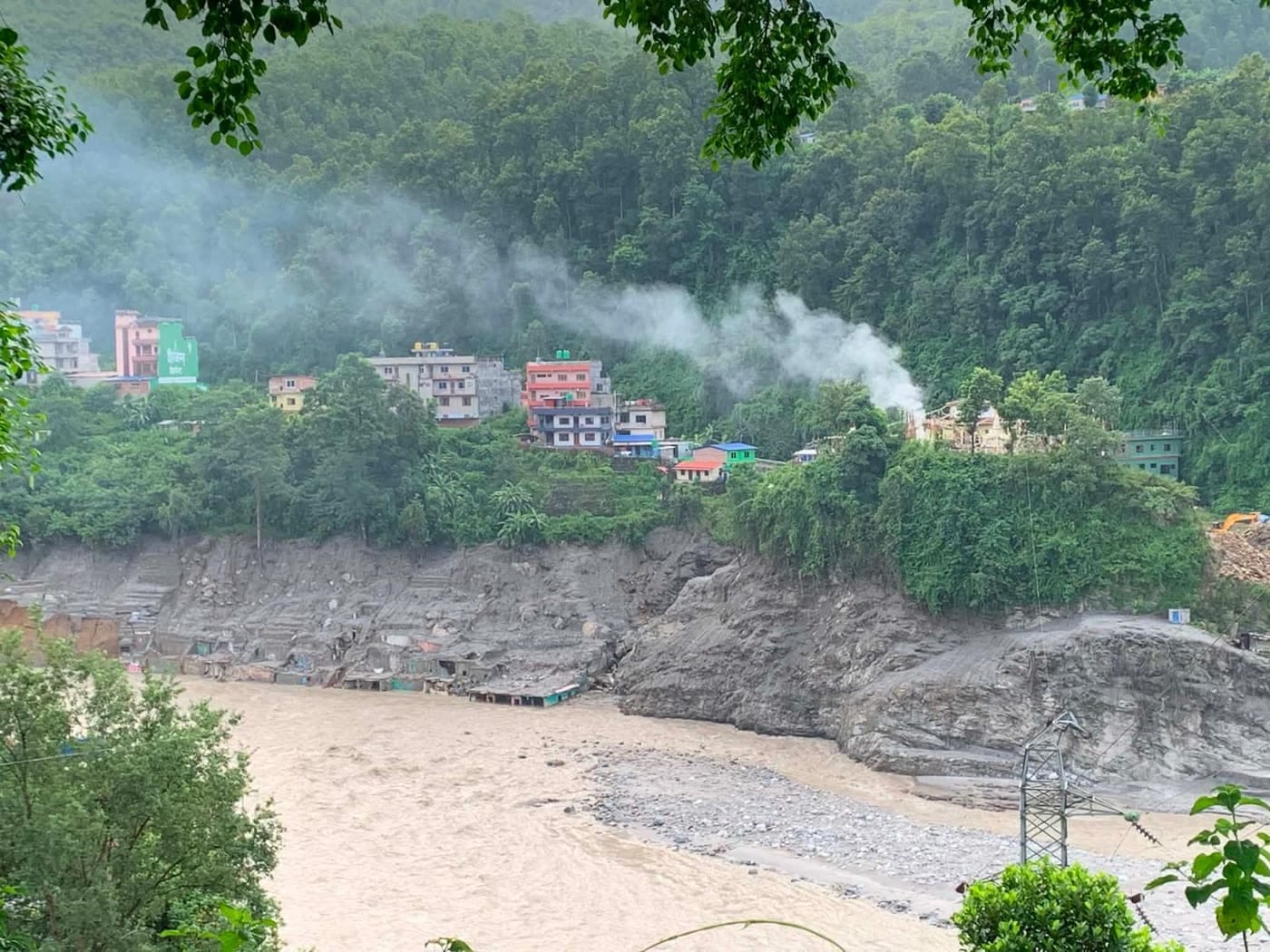 Der angeschwollene Fluss hat unterhalb der Häuser eine hohe Abbruchkante gerissen